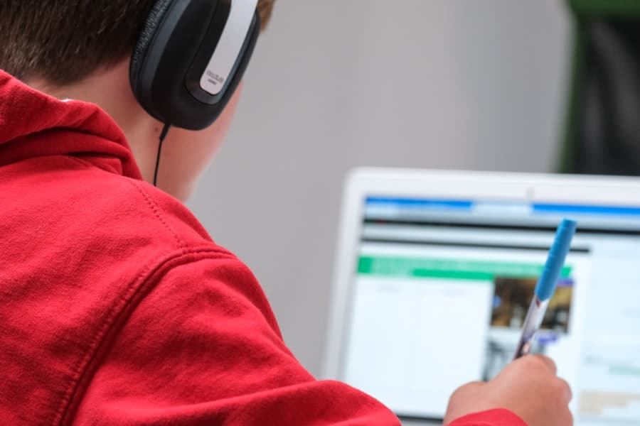 A student in an online class with headphones and a laptop